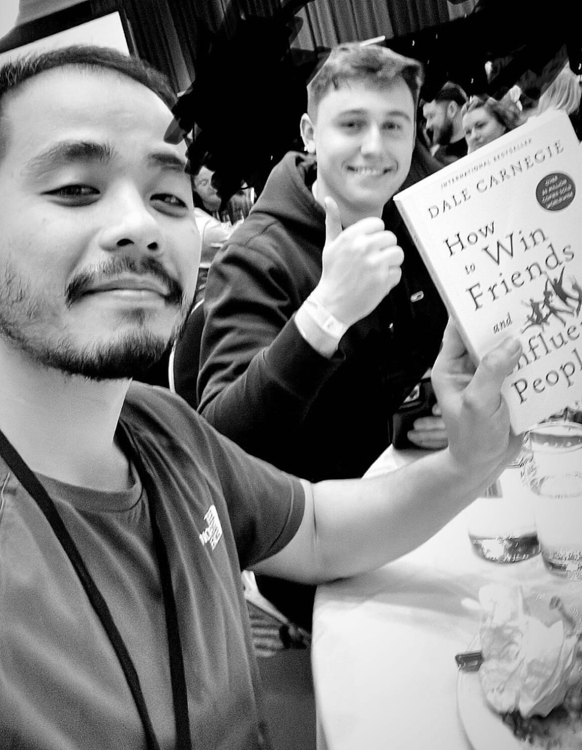Best Book to Read for Self-Development: How to Win Friends and Influence People (Summary) Two men smiling as they pose with a copy of Dale Carnegie's 'How to Win Friends and Influence People', which they recommend as the best book to read for self-development.