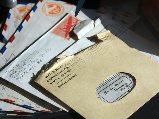 Handwritten letters and envelopes on a desk, inspiring how to write a letter to a friend