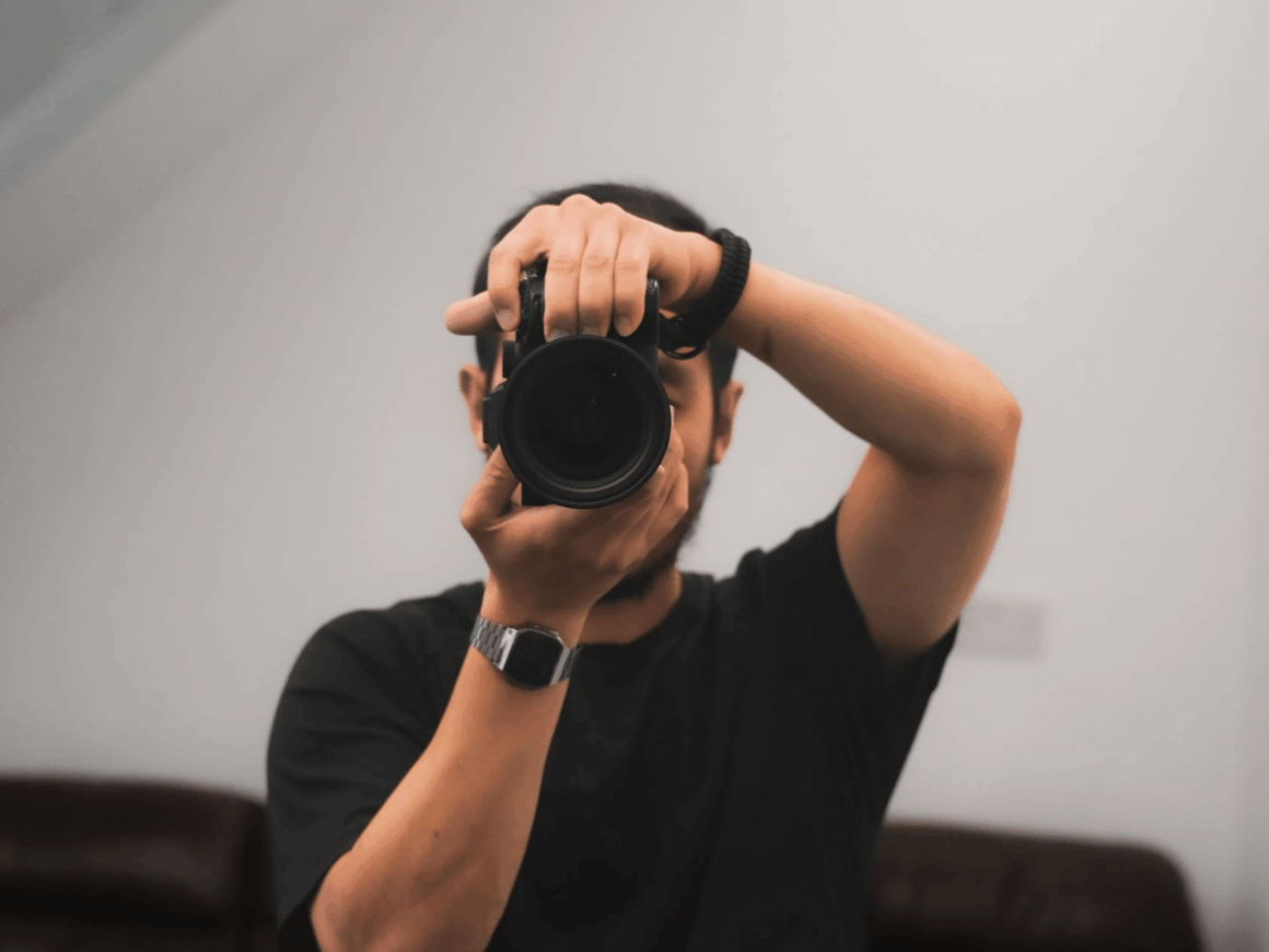 Person using a camera to practice photography, one of the most popular creative hobbies that anyone can start today. 